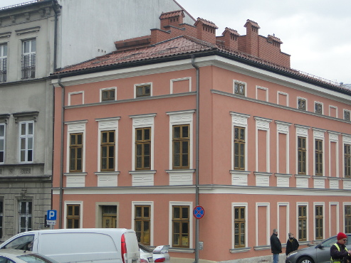 kamienica z łososiową elewacją i pociągłymi oknami