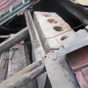 Rozebrane korony komina i widoczne zużyte pokrycie z blachy.