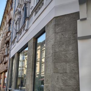 Barlickiego 4 widok elewacji z pasem witryn oraz kamienną okładziną w parterze po konserwacji. 
