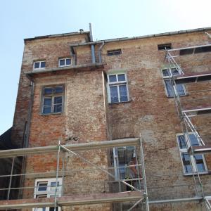 Cieszyńska 14 ściana podwórzowa skucie odparzonych tynków do cegły.